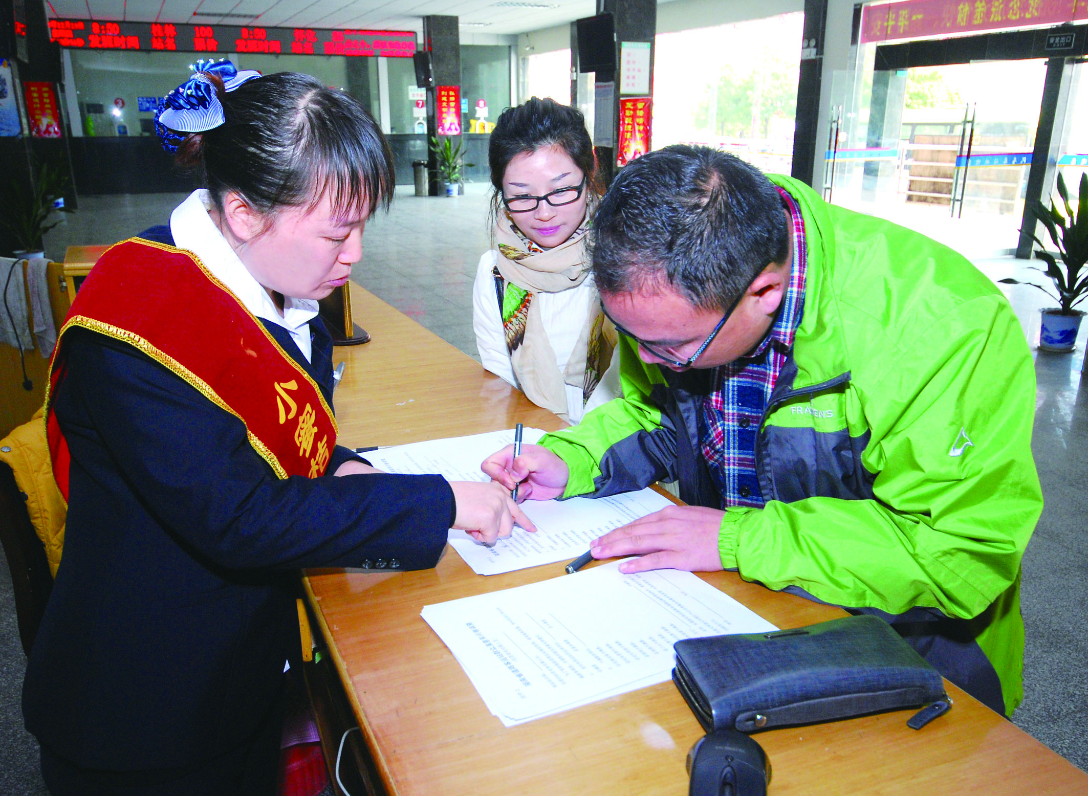 圖為洞口汽車(chē)總站站務(wù)人員在熱心為旅客服務(wù)。